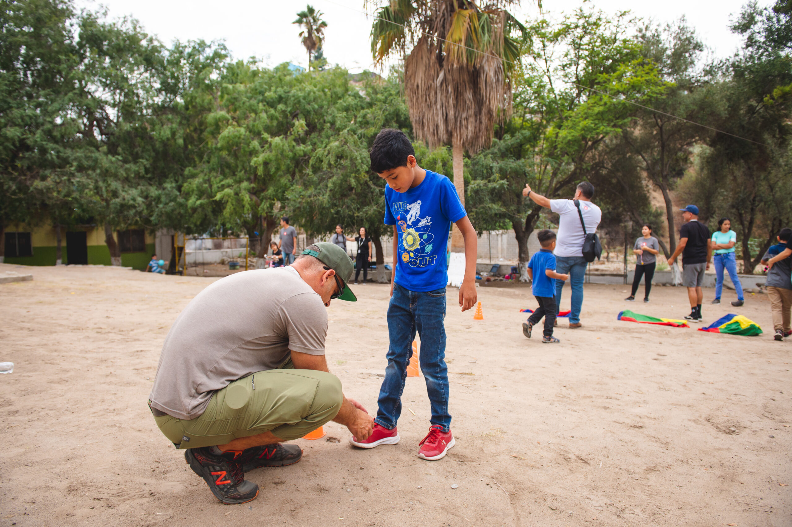 San Diego charity Unity 4 Orphans' volunteer tying a child's shoe