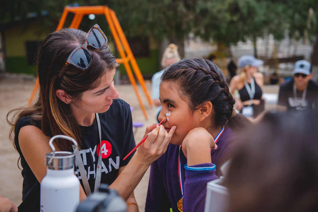 Unity 4 Orphans Julia Valencia Painting a Child's Face in Mexico