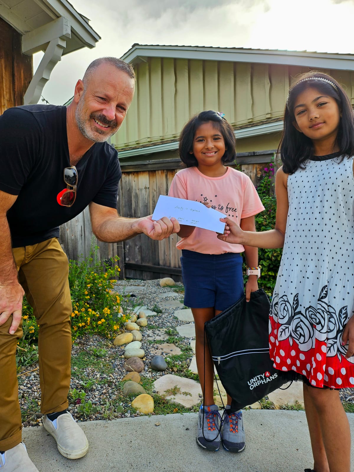 U4O's founder, Joe, with two kids, Aashi and Aanya at their lemonade stand fundraiser to help vulnerable children.